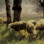 Sheep grazing in a field with trees and a landscape in the background